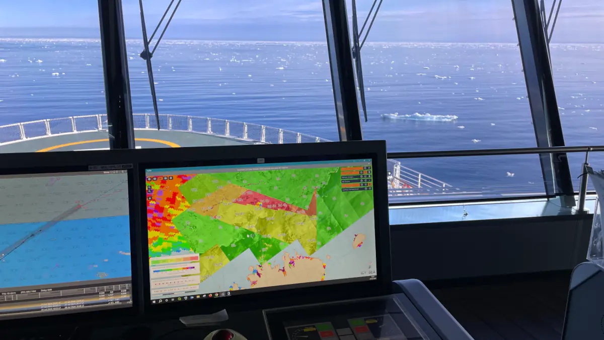 View from a ship’s bridge sailing through icy waters, with a laptop in the foreground that runs IcySea.